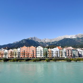 Innpromenade Innsbruck mit historischen Häusern und Bergen im Hintergrund
